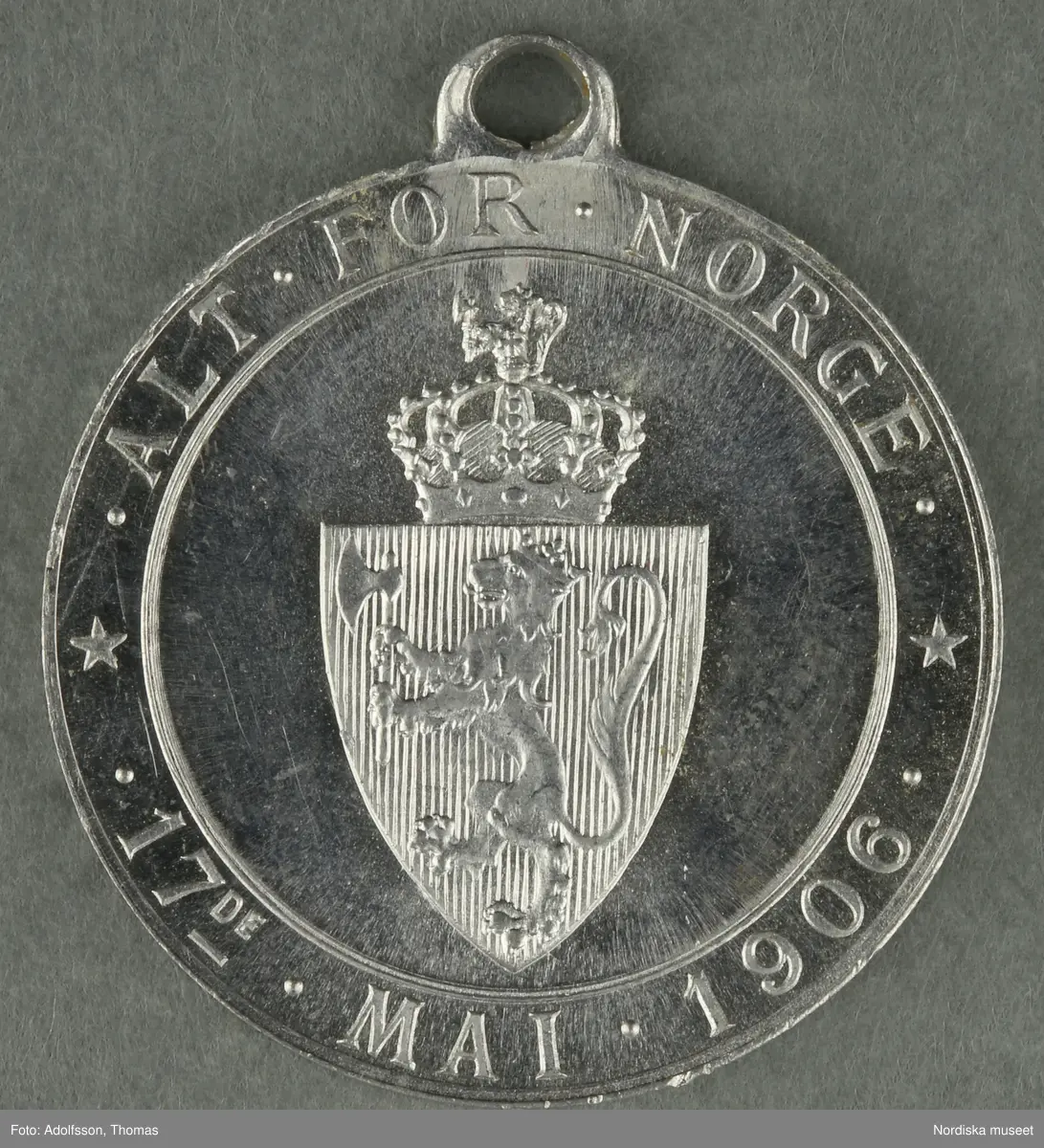 Huvudliggaren:
"a-y, Minnesmedaljer, norska, över den 17 maj; av aluminium (1 av vit metall) 24 st. från åren 1884-1907.
Gåva 28/5 1907. Läffler, Fritz, professor, Djursholm."