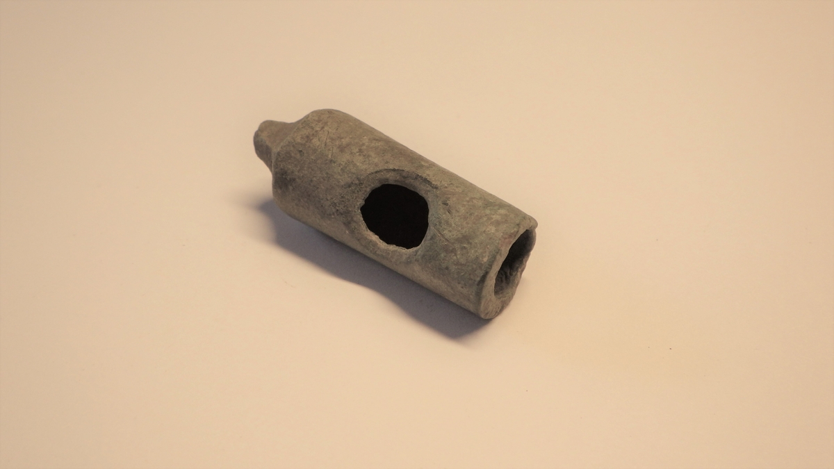 MALV: L. 40 MM ST. DIAM. 16 MM, DEN INDRE BEVEGELIGE DEL AV EN BIERHANE, KONISK, INNSNEVRING ØVERST FOR HÅNDTAK, DETTE ER AVBRUKKET. HUL INNVENDIG. ÅPNING PÅ SIDEN OG I BUNNEN. (S. GRIEG, MIDDELALDERSKE BYFUNN, FIG. 128)