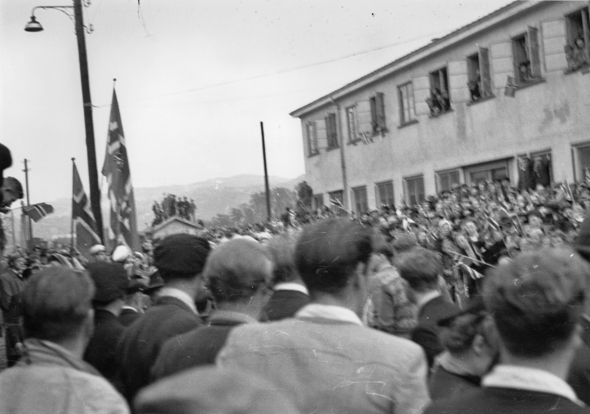 Grinifangene blir mottatt av fremmøtte på Jernbanestasjonen på Eie, 10. mai 1945.