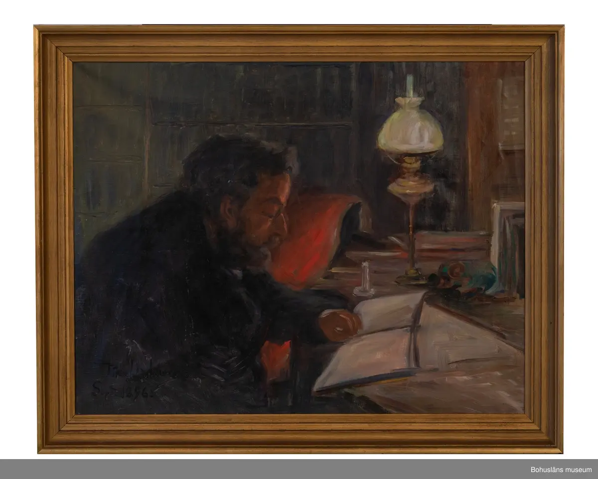 Skrivbordsporträtt av Alfred Grenander vid sitt skrivbord i skenet av en fotogenlampa.