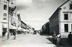 Storgatan, korsningen mot Bäckgatan, Växjö 1923. Till vänster ser man (närmast) familjen Feuks fastighet (kvarteret 
Klostret 8), med bl a Oscar Karlssons uraffär, följt av diverse andra hus i kvarteren Klostret och Sunaman. Till höger ser 
man bl a apoteket Sigfrids lokaler i kvarteret Blenda (Blenda 1).