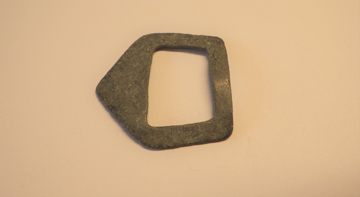 MALV: H. 29 MM L. 30 MM, TRAPESFORMET, DEN BREDESTE ENDEN GÅR UT I EN SPISSFLIK.