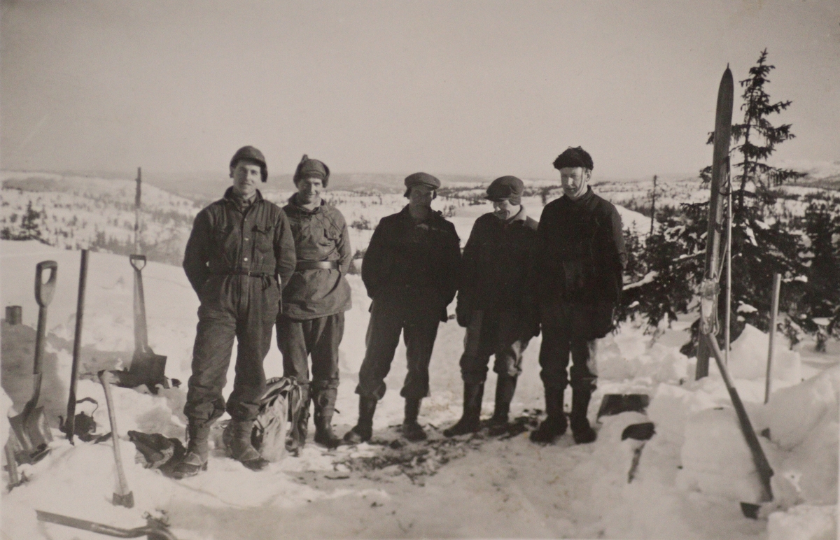 Snømåking på Baklifjellet i forbindelse med bygging av kraflinja fra Lisleherad. Det var så mye snø at man måtte måke traktorveien for at beltetraktoren kunne komme fram !
Fra v: Olav K Dalviken (1913-1994), Jon K Dalviken (1915-2006) og 3 ukjente.