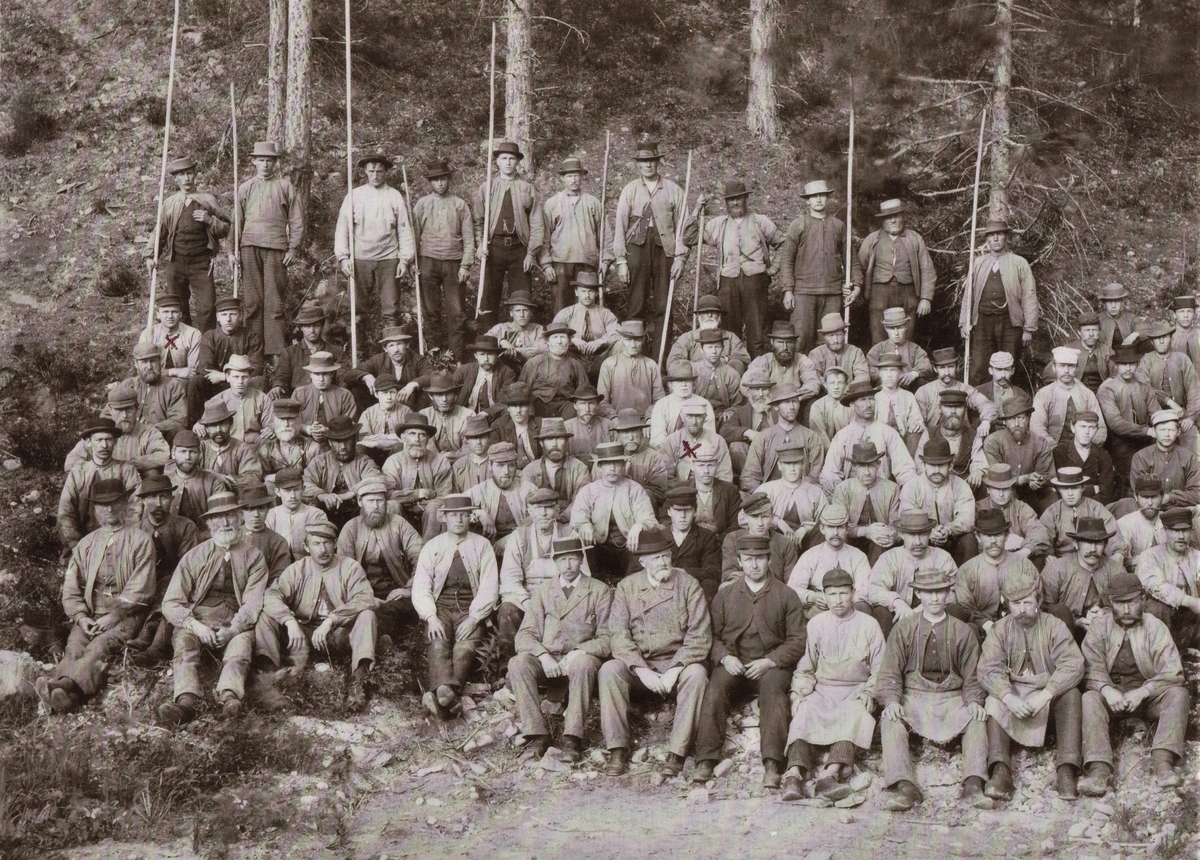 Dagskiftet ved Labro Tresliperi. Det er to røde kryss på bildet. Han som sitter i midten er Halvor Thomassen d. 1914, oldefar til bildets eier. (Ånnestad er også brukt som etternavn.) Kryss på person i venstre kant: Halvors sønn Sigvart. Emigrerte til USA. Hans Gulli (sluttet 1906), sitter som nummer 9 fra venstre i 5 rekke.