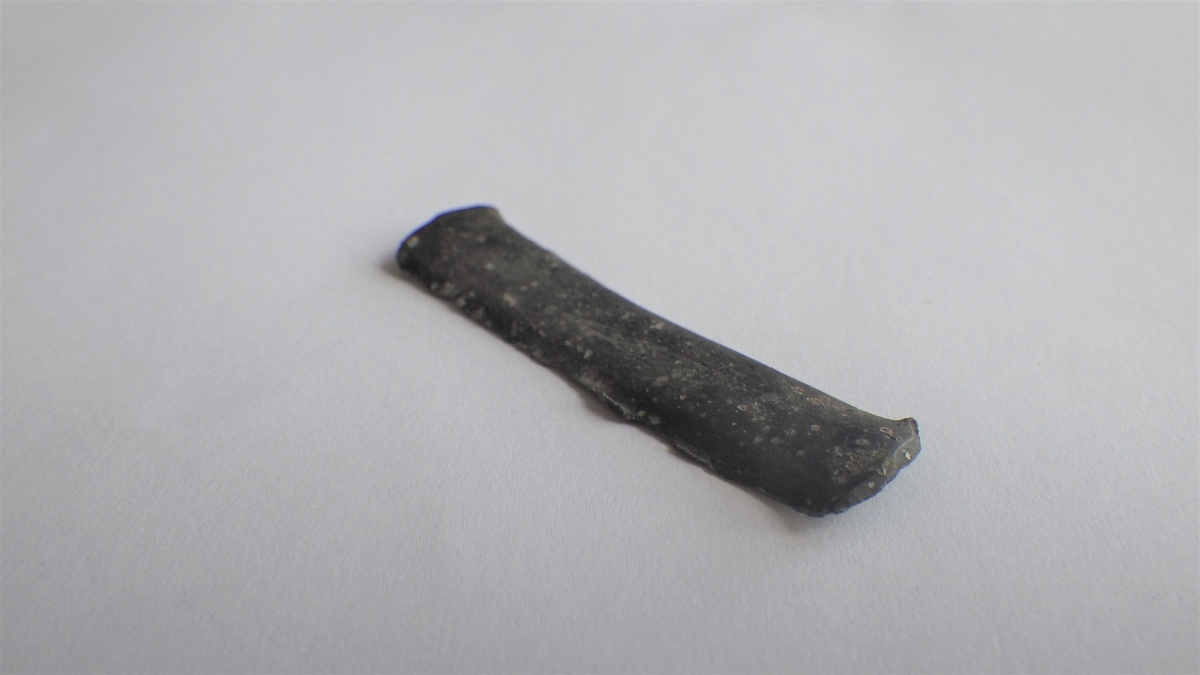MÅL: L. 43 MM B. 9 MM, SMAL, REKTANGULÆR PLATE MED AVRUNDEDE ENDER. SVAKT BØYET OM LENGDEAKSEN.
