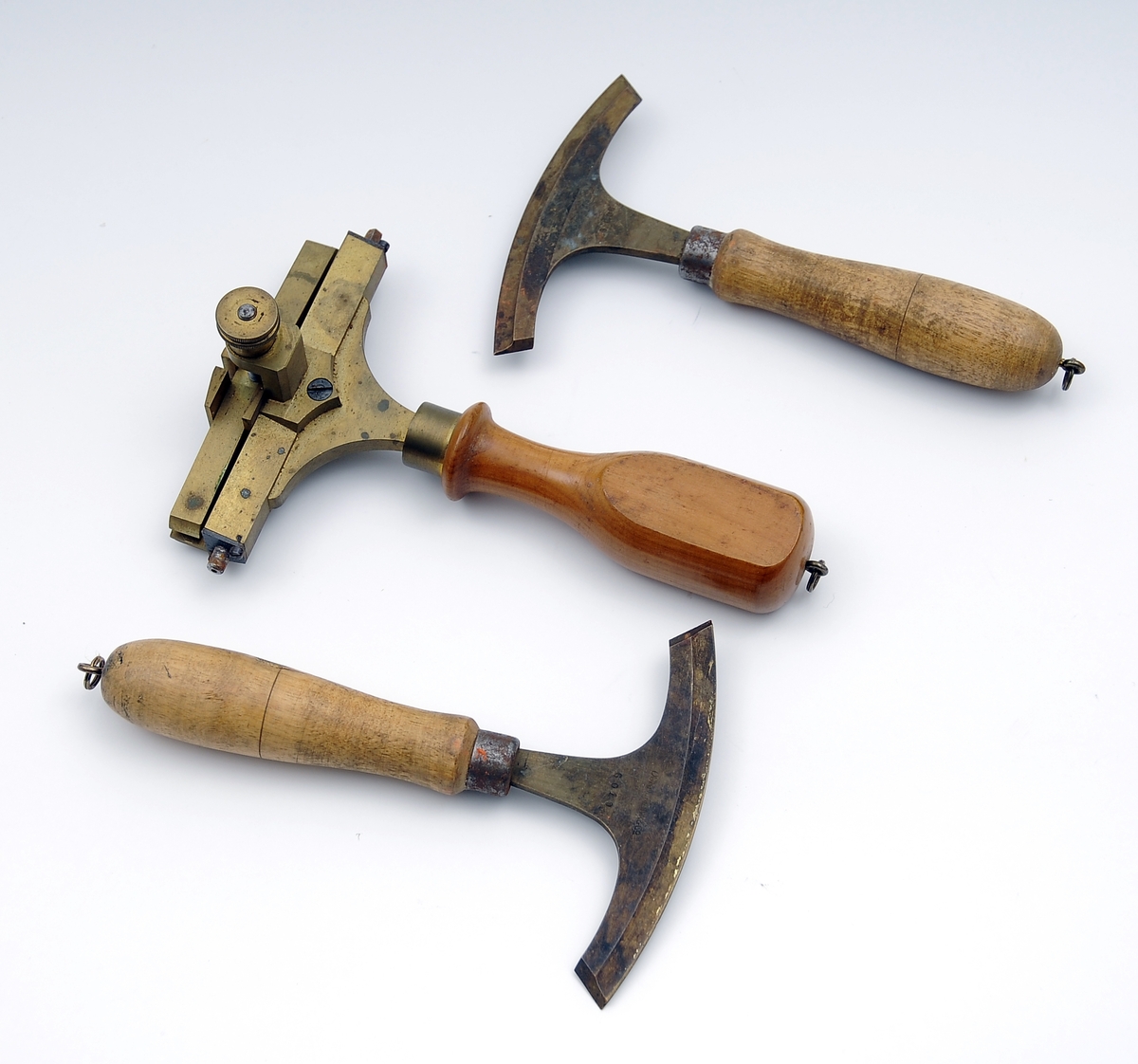 En liten kasse med en forgyllerpute og en skuff hvor det oppbevares ulike bokbindervertøy/forgyllerverktøy. Utstyret består av 5 ulike fileter/forgyllingsverktøy, 1 skiftekasse, 1 kniv, et stykker rødt kritt, 2 små ekser og flere ark med bladgull.
Dette er opprinnelig registrert som skomakerverktøy. Kan det ha blitt brukt til å prege skolær?