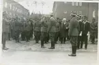 Flera officerare står enskilt och i grupper på kasernområdet,I 4.