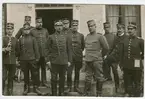 Ett tiotal officerare i olika militära uniformer står samlade
framför en byggnad.