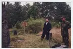 Minnessten med omgivning,två besökare.