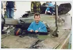 Barn som undersöker infanterikanonvagn IKV 91. Militärklädd person i bakgrunden.
Sannolikt i Linköping under en besöksdag vid I 4 eftersom övriga bilder i samma är därifrån.