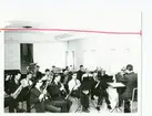 Militär blåsmusikorkester övar med musikledare.
