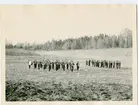 Musikkår mfl militärer i öppen terräng.