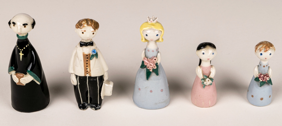 Brudfölje om fem figuriner: präst, brud, brudgum och två tärnor. Formgivare Dorothy Clough, 1955, Gefle Porslinsfabrik.
Prästen är 10 cm hög, bruden 9,5 cm, brudgumen 10 cm, näbbarna 6,7 cm.