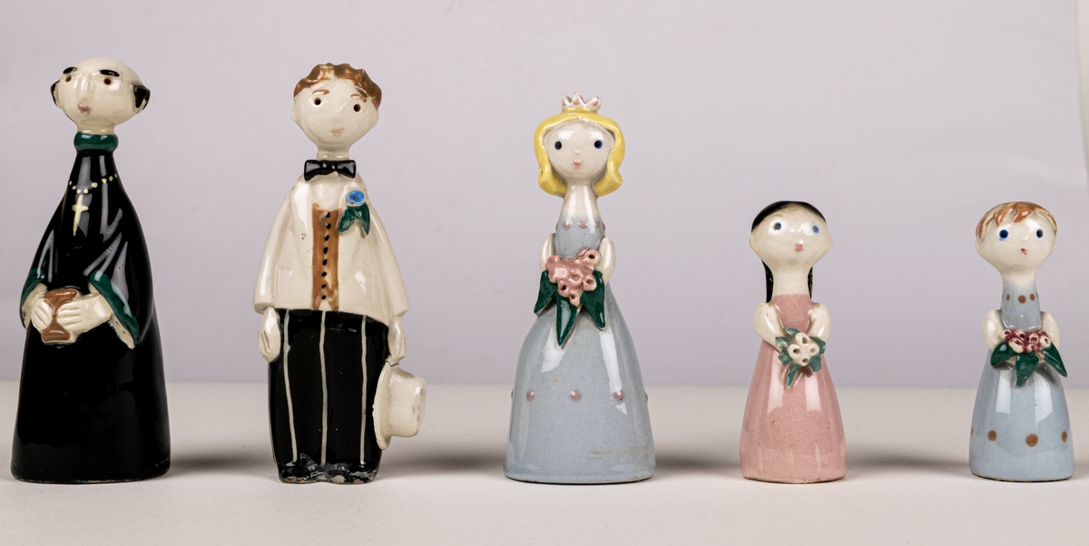 Brudfölje om fem figuriner: präst, brud, brudgum och två tärnor. Formgivare Dorothy Clough, 1955, Gefle Porslinsfabrik.
Prästen är 10 cm hög, bruden 9,5 cm, brudgumen 10 cm, näbbarna 6,7 cm.