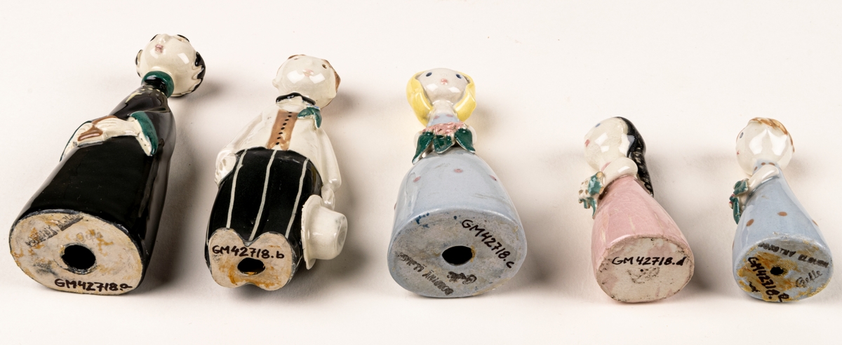 Brudfölje om fem figuriner: präst, brud, brudgum och två tärnor. Formgivare Dorothy Clough, 1955, Gefle Porslinsfabrik.
Prästen är 10 cm hög, bruden 9,5 cm, brudgumen 10 cm, näbbarna 6,7 cm.