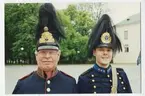Två personer i gamla uniformer samt hjälmar med svarta plymer
 på borggården, Linköping.(troligen högtidstillfälle)
