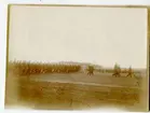 5.kompani Malmen 3/9 1922. Några militärer förflyttar sig på plan yta medan ett par långa raka led med civilklädda följer efter.
