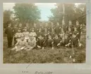 En militärgrupp samlad i Malmslätt i olika uniformsmodeller.
Noteringar runt fotot: 
Vid fotos överkant: Albäck markerad med blyertsstreck (nr 3 från vänster bakre raden)
Vid siffran 1; Oskar Karlsson Hernell
Vid siffran 2; Jonsson.
I nedkant av fotot ett snett streck markerar Lönn (nedersta raden).