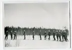 Militärer i startläge för skidåkning.