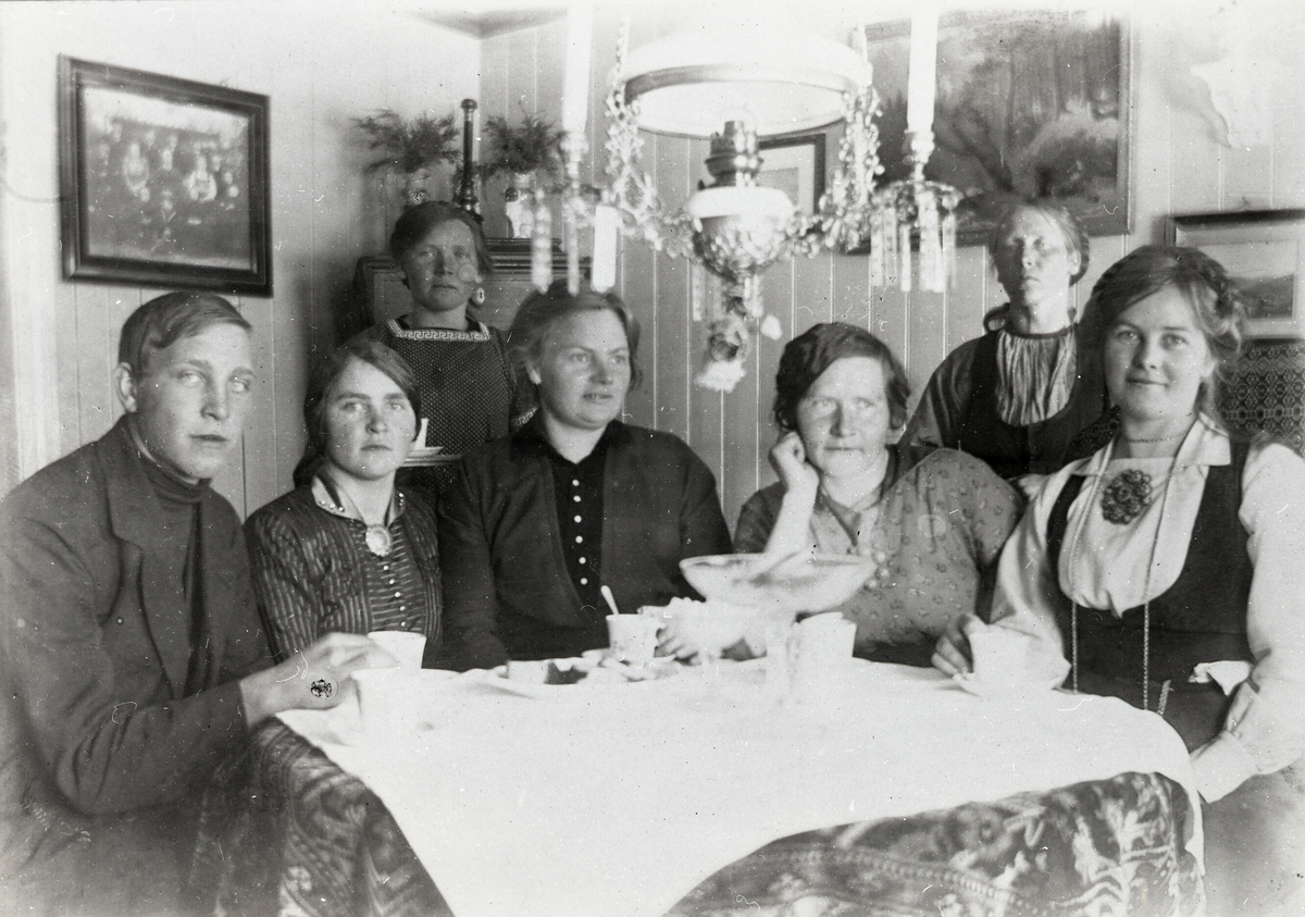 Kaffeselskap i oppstugo i Krossvegen.  F.v Johannes Saga f. 1897 d. 1981, Anne H. Saga f. 1894, Ronnaug H. Saga f. 1888 d. 1976, Dordi E. Nordbø f. 1882 d. 1966, Mari Saga f. 1882 d. 1973, Ingeborg Skogen f. 1872 d. 1958 og Bergit E. Nordbø (Bia) f. 1890 d. 1936.