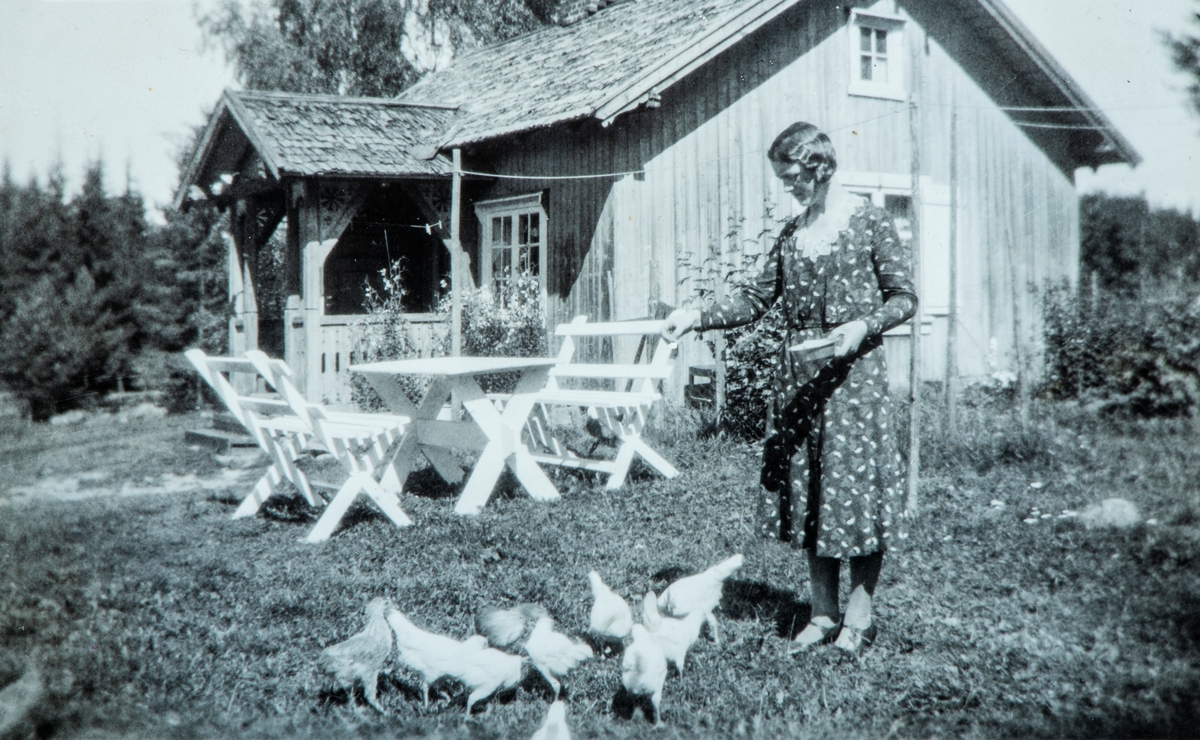 Mina Dalby mater hønene ute på gårdsplassen på Dalby, Ottestad i 1932.