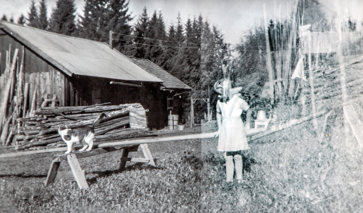 Dalby, Ottestad 1950. Anne Marie Paulsen og katten "Piril" ute på tunet på Dalby.