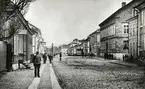 Storgatan Växjö, österut, ca 1880. Till vänster ser man husen i kvarteren Nunnan och Klostret, till höger några av husen i kvarteren Stormen, Blenda och Unaman. I fjärran ser man gårdsbebyggelsen vid Östregård.