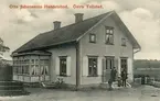 Otto Johanssons handelsbod i Östra Tollstad var från 1903 inrymd i lägenheten Fridensborg på Fröstads ägor. Rimligtvis är det handlaren själv vi ser på trappan med sina två överlevande barn.