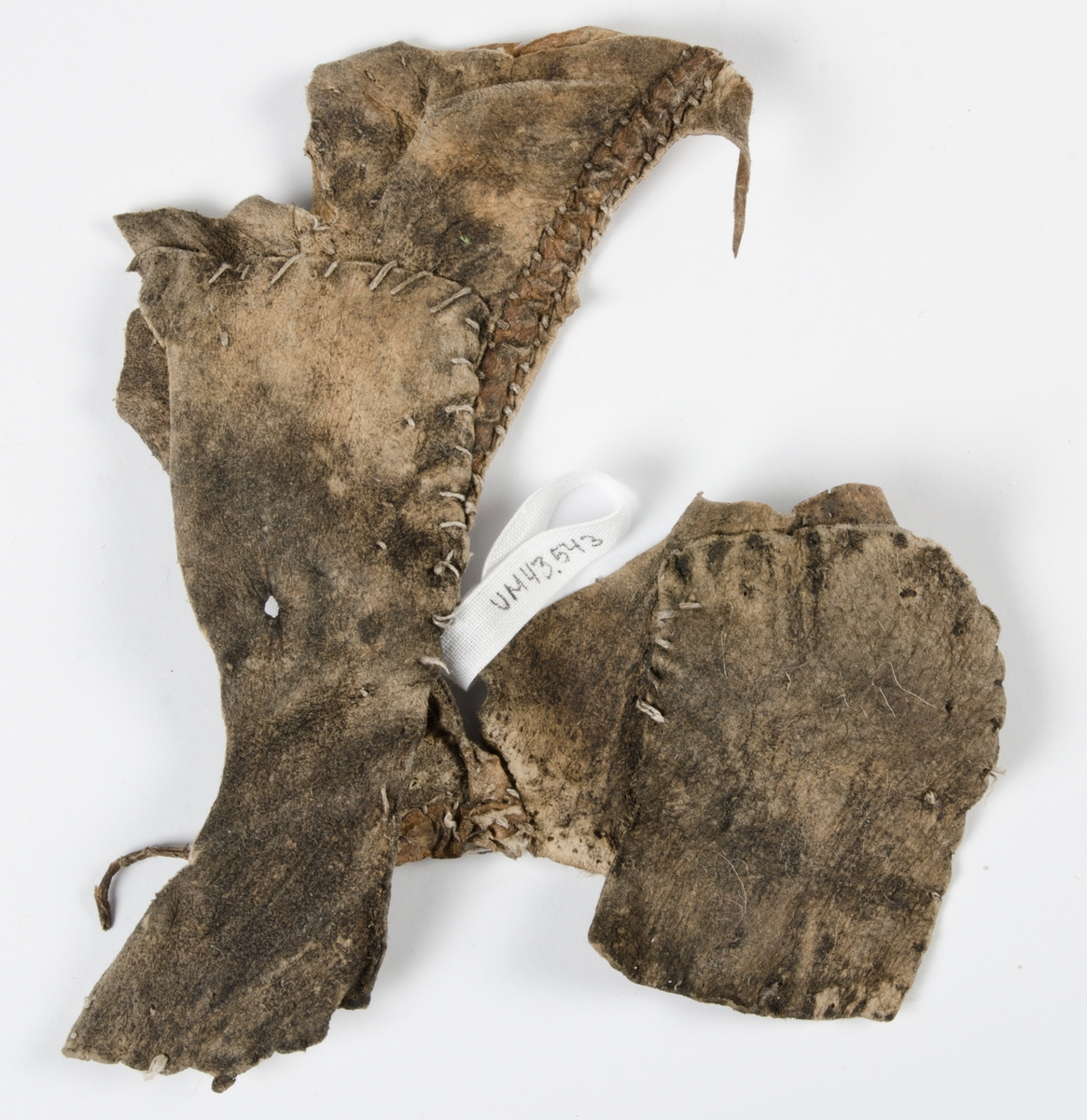 Fragment av pälsplagg. Eventuellt del av ärmhål, sidostycke och bakstycke. Osäkert vad det varit del av för plagg.