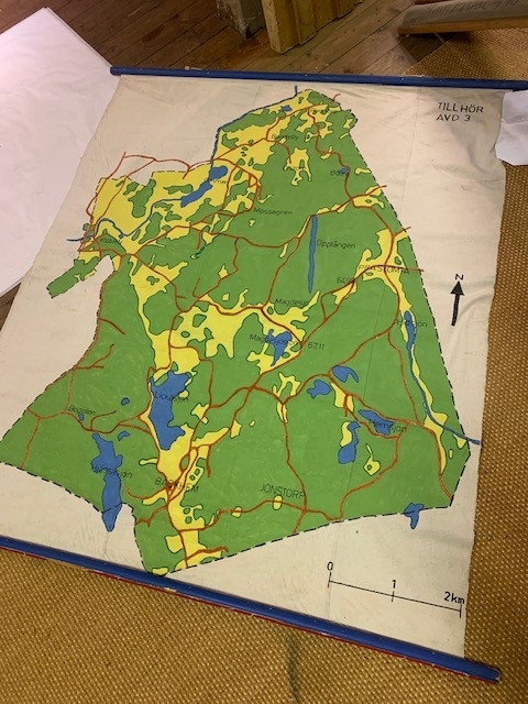 Plansch med karta över område utanför Ljungsbro (skjutfält?) Målad på textil  
Trälist i toppen och botten 
Går att rulla