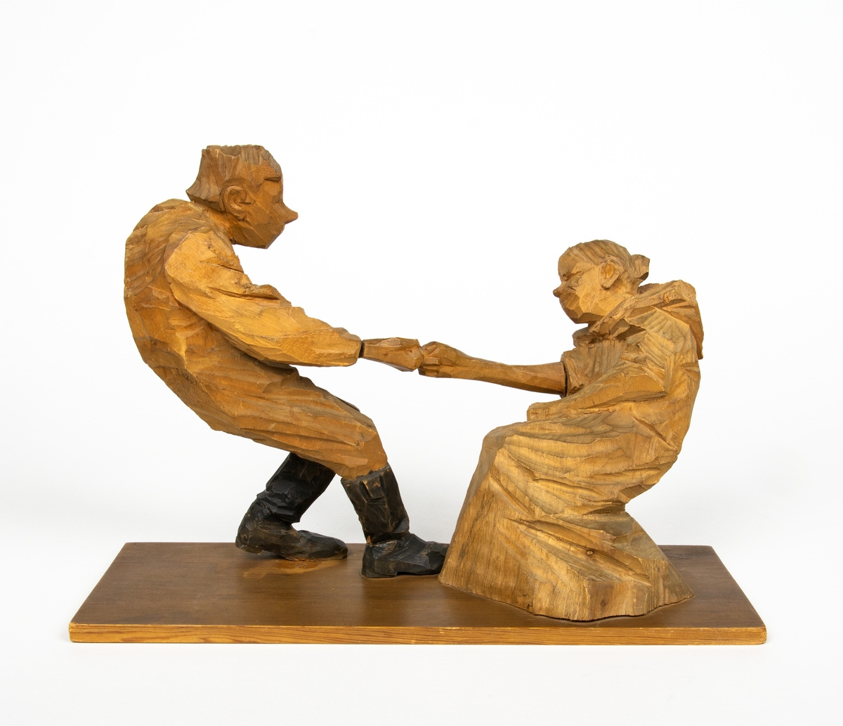 Skulptur i trä av Döderhultarn. Skulpturen föreställer två figurer, en man och en hustru i en dragkamp, så kallad ”fingerkrok”. På figurens fotplatta finns en dedikation: ”Från Axel Petersson till Flygaren å vännen Rodéhn 2/9 1919. En ringa gärd af tacksamhet för tvänne i allo förstklassiga ”himmelsfärder”. Länge lefve Br Rodéhn!!! D.S".
Jämte dedikationen finns konstnärens signatur synlig i form av en stämpel.