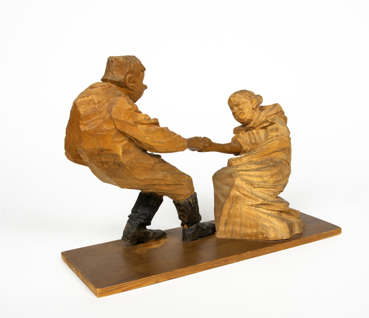 Skulptur i trä av Döderhultarn. Skulpturen föreställer två figurer, en man och en hustru i en dragkamp, så kallad ”fingerkrok”. På figurens fotplatta finns en dedikation: ”Från Axel Petersson till Flygaren å vännen Rodéhn 2/9 1919. En ringa gärd af tacksamhet för tvänne i allo förstklassiga ”himmelsfärder”. Länge lefve Br Rodéhn!!! D.S".
Jämte dedikationen finns konstnärens signatur synlig i form av en stämpel.