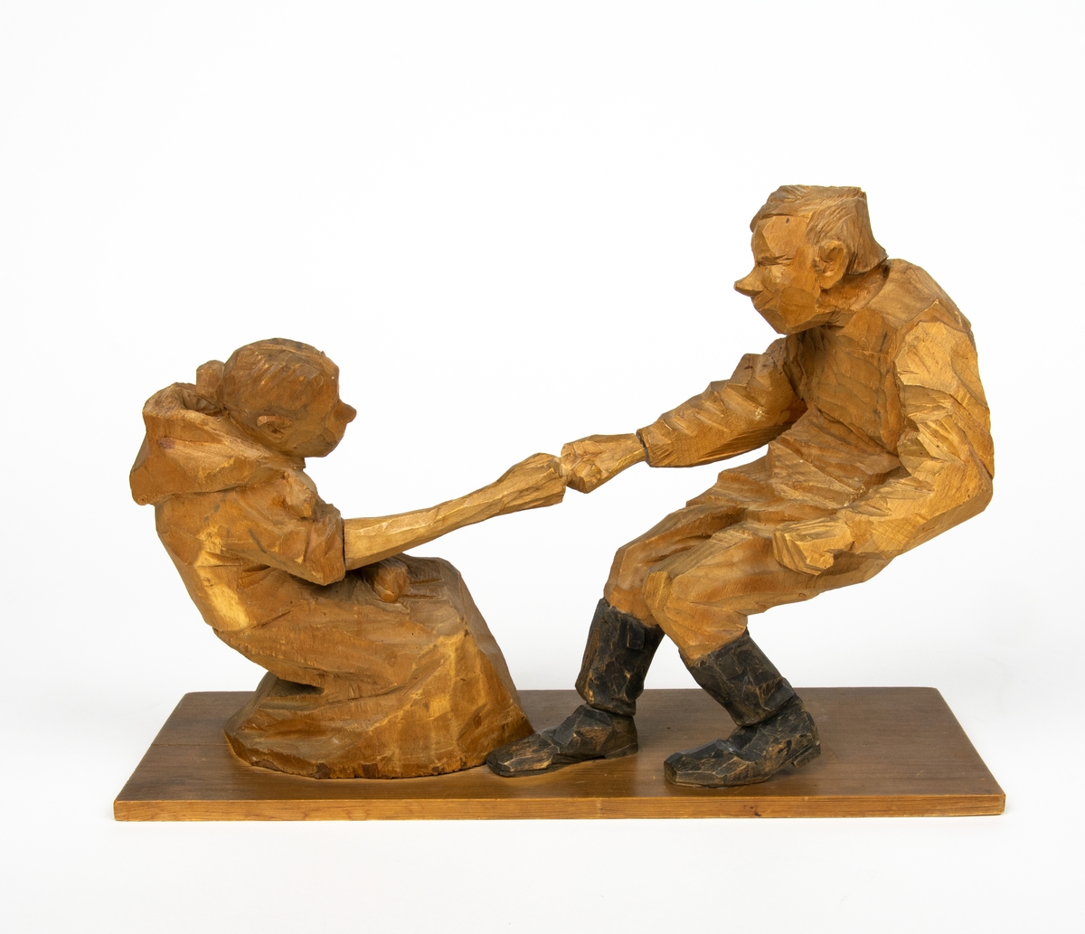 Skulptur i trä av Döderhultarn. Skulpturen föreställer två figurer, en man och en hustru i en dragkamp, så kallad ”fingerkrok”. På figurens fotplatta finns en dedikation: ”Från Axel Petersson till Flygaren å vännen Rodéhn 2/9 1919. En ringa gärd af tacksamhet för tvänne i allo förstklassiga ”himmelsfärder”. Länge lefve Br Rodéhn!!! D.S".
Jämte dedikationen finns konstnärens signatur synlig i form av en stämpel.