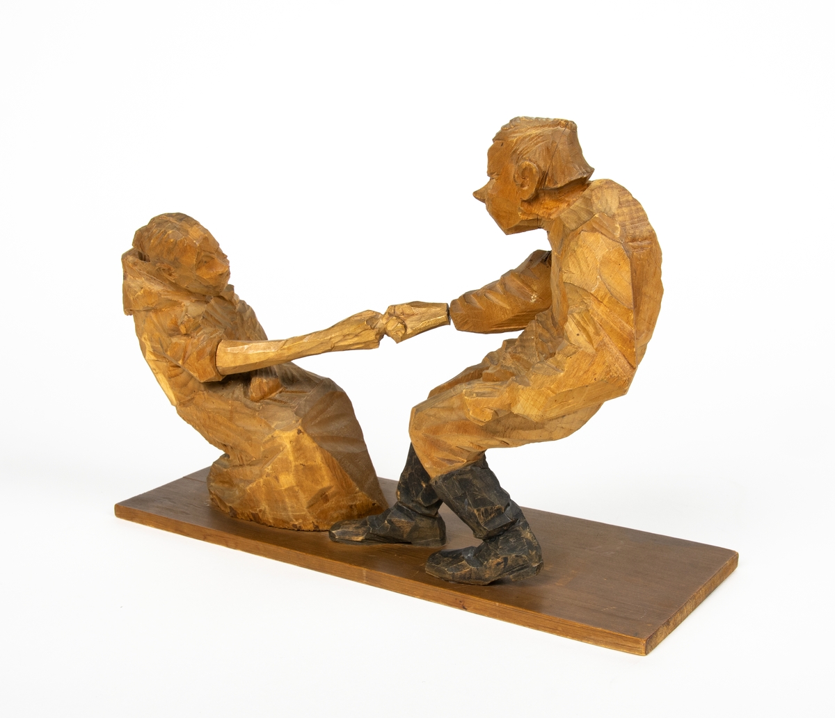 Skulptur i trä av Döderhultarn. Skulpturen föreställer två figurer, en man och en hustru i en dragkamp, så kallad ”fingerkrok”. På figurens fotplatta finns en dedikation: ”Från Axel Petersson till Flygaren å vännen Rodéhn 2/9 1919. En ringa gärd af tacksamhet för tvänne i allo förstklassiga ”himmelsfärder”. Länge lefve Br Rodéhn!!! D.S".
Jämte dedikationen finns konstnärens signatur synlig i form av en stämpel.