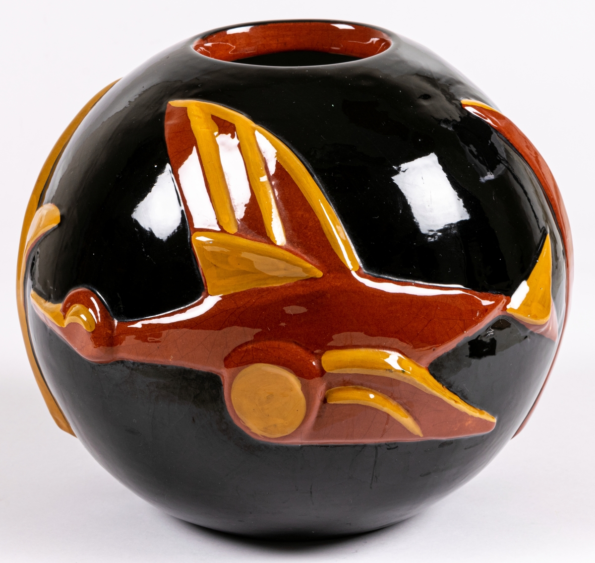 Vas modell 4298, formgiven av Maggie Wibom vid Bo Fajans, glaserad lergods med reliefmotiv i form av en flygandel fågel (gås) i rött och gult mot svart botten. Glasyr LW.