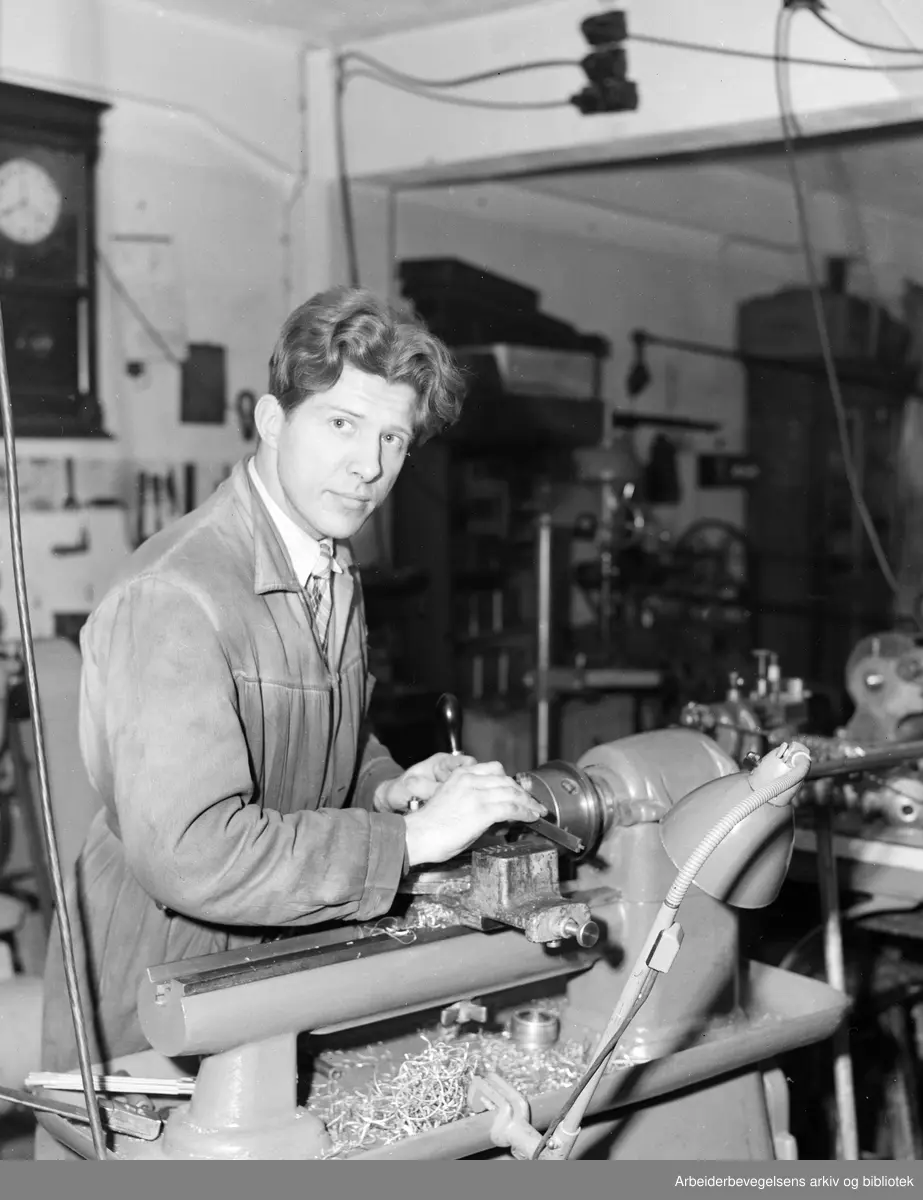 Finmekaniker Raymond Bovind arbeider i et verksted på Lilletorget 1 i Oslo. Desember 1951.