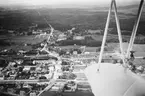 Flygbild av oidentifierat samhälle omkring 1930. Med flygplansvinge i förgrunden.
