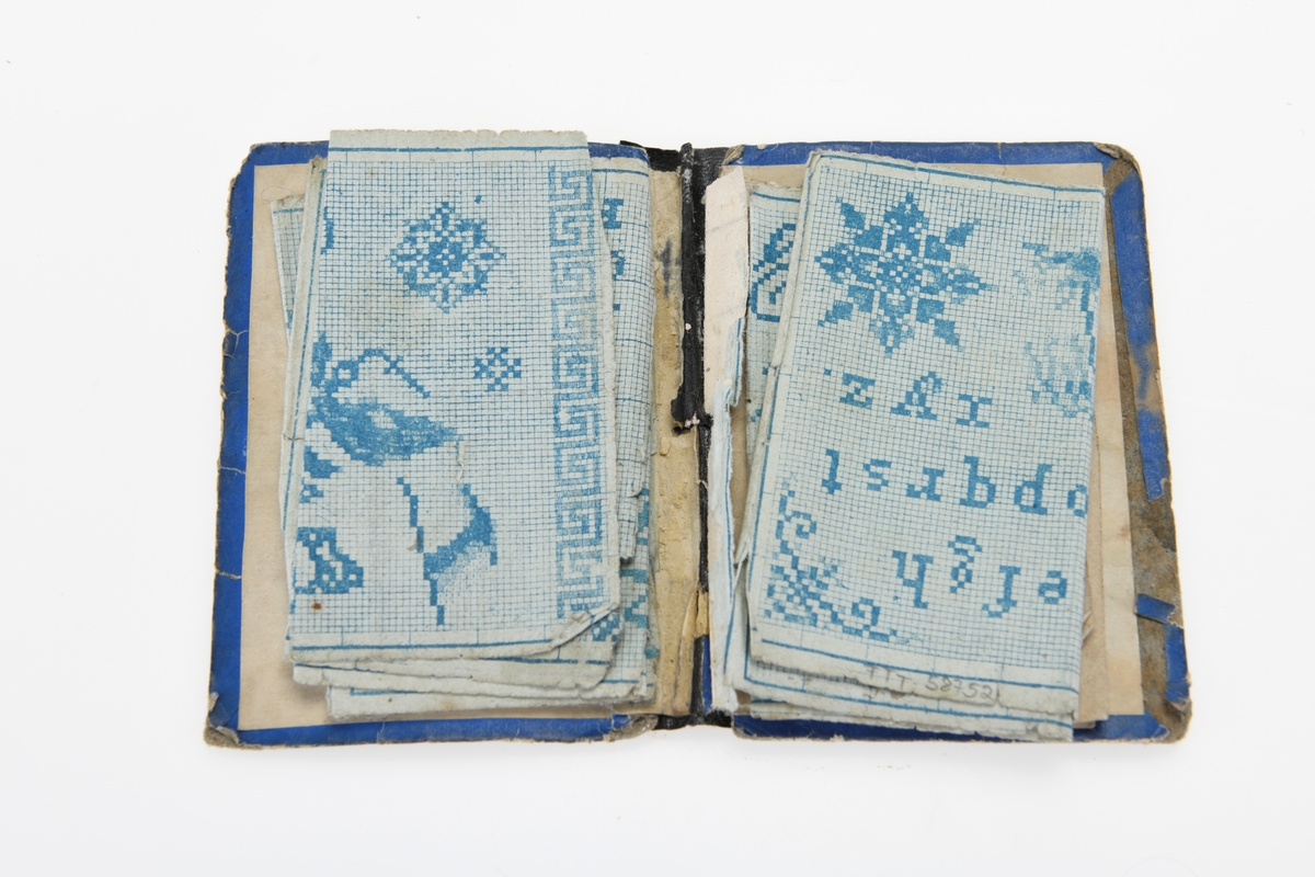 Et lite mønsterhefte med omslag av blå papp med gullmønster. Heftet er limt med svart papir i ryggen. På forsiden er det en "gullramme" med et portrett av en mann og en kvinne. Påå baksiden er det en lignende "ramme" med tekst, men gullfargen er så slitt at det er vanskelig å tyde hva som står. I heftet er det 6 mønsterark av ulik størrelse, kun ett av dem henger fast i permen. Mønstrene er trykt på hvitt papir med blått rutemønster og utfylling. Arkene har mønster til ulike versjoner av alfabetet (gotisk, løkkeskrift, store og små bokstaver), tallrekker, små motiv, ulike border og monogram.