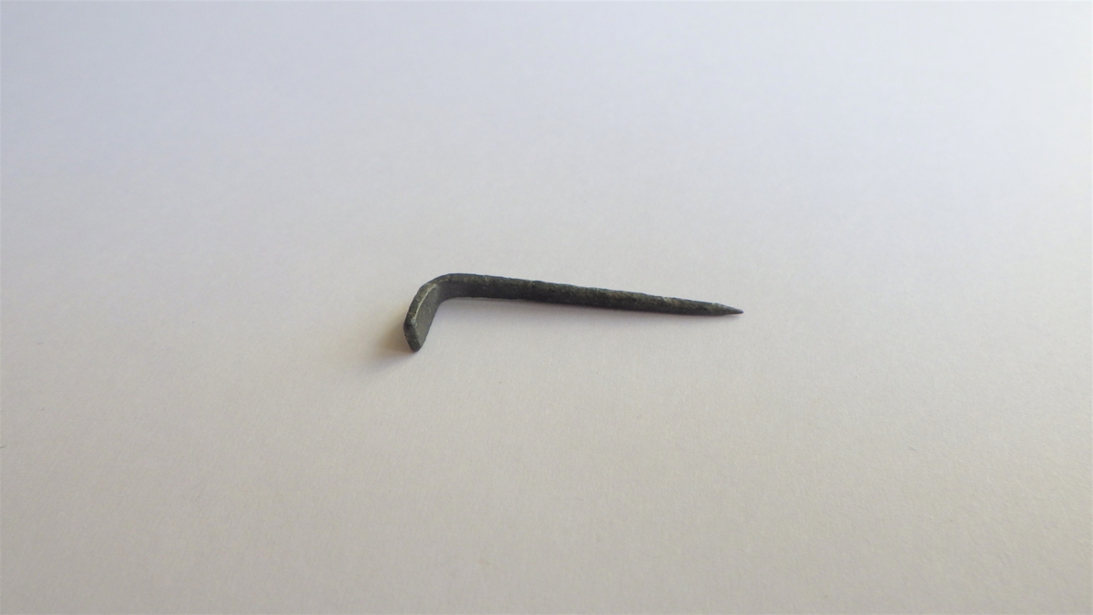 MALV: L. 18 B. 3 MM, TEN, TILSPISSET I ENE ENDEN, AVFLATET, BREDERE OGOMBØYET I RETT VINKEL. SE HK 4827. 