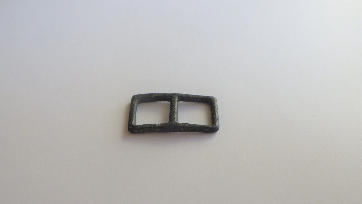MALV: 26*13 MM  B. 2 MM, REKTANGULÆR FORM LAGET AV ET 2 MM BREDT MATERIALEMED TILNÆRMET RUNDT TVERRSNITT. 