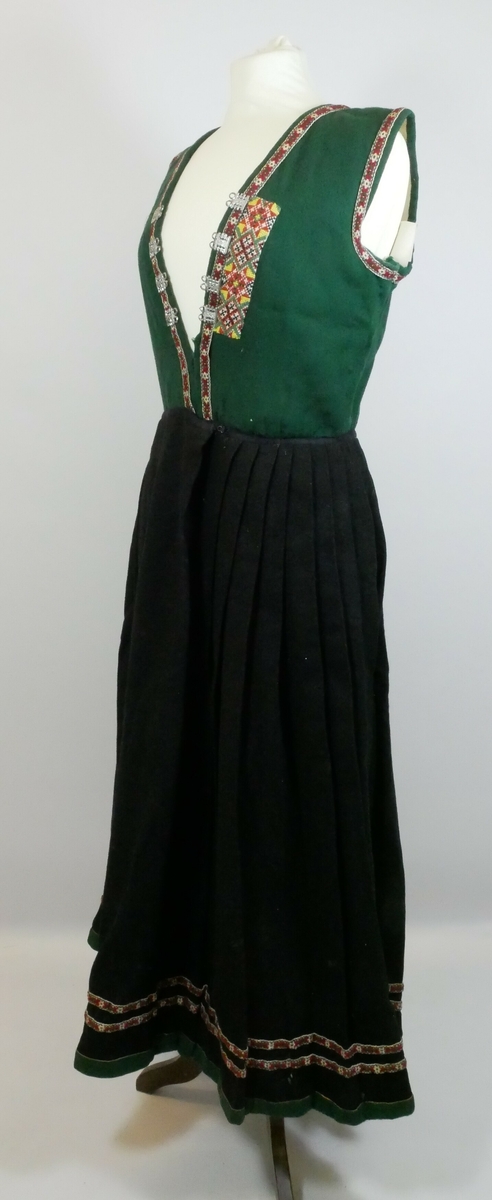 Stakk og liv til sunnfjordsbunad som er sydd sammen. Livet er grønt med bånd rundt ermene og på forstykket. Tre bånd på bakstykket. En maljeklut på venstre side av forstykket. Fire maljer på hver side. Stakken er plissert med grønn kant nederst og to påsydde bånd nederst