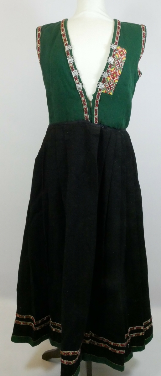 Stakk og liv til sunnfjordsbunad som er sydd sammen. Livet er grønt med bånd rundt ermene og på forstykket. Tre bånd på bakstykket. En maljeklut på venstre side av forstykket. Fire maljer på hver side. Stakken er plissert med grønn kant nederst og to påsydde bånd nederst