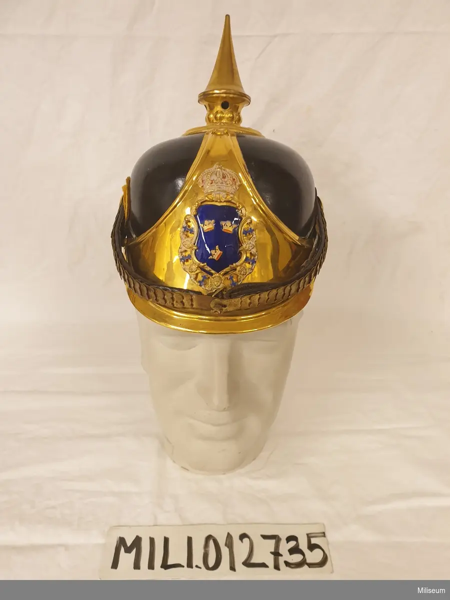 Kask m/1894 av pressat läder och med förgyllda mässingsdetaljer.