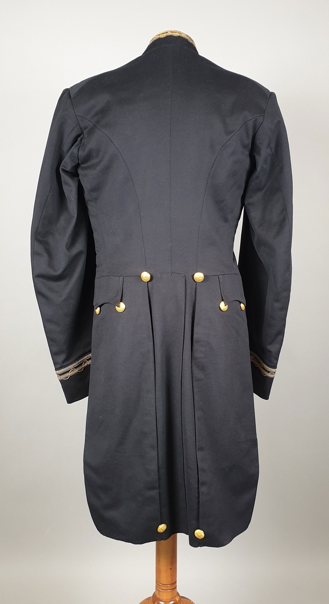 Svart uniformsjakke med snipp. Broderinger på krage og ytter på ermene med metalltråd i gull og sølvfarge. Metallknapper i front og på snippen bak med riksløve. För av svart silke.