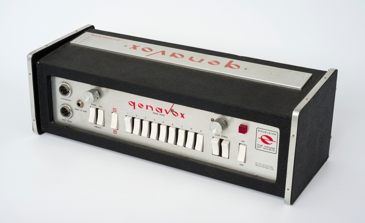 Excelsior Genavox Solid State 1500. Lydforvrenger til trekkspill med en mengde effekter. Tilkoblingsmulighet til trekkspill, forsterker og fotpedal. På baksida henger en bagasjelapp.
