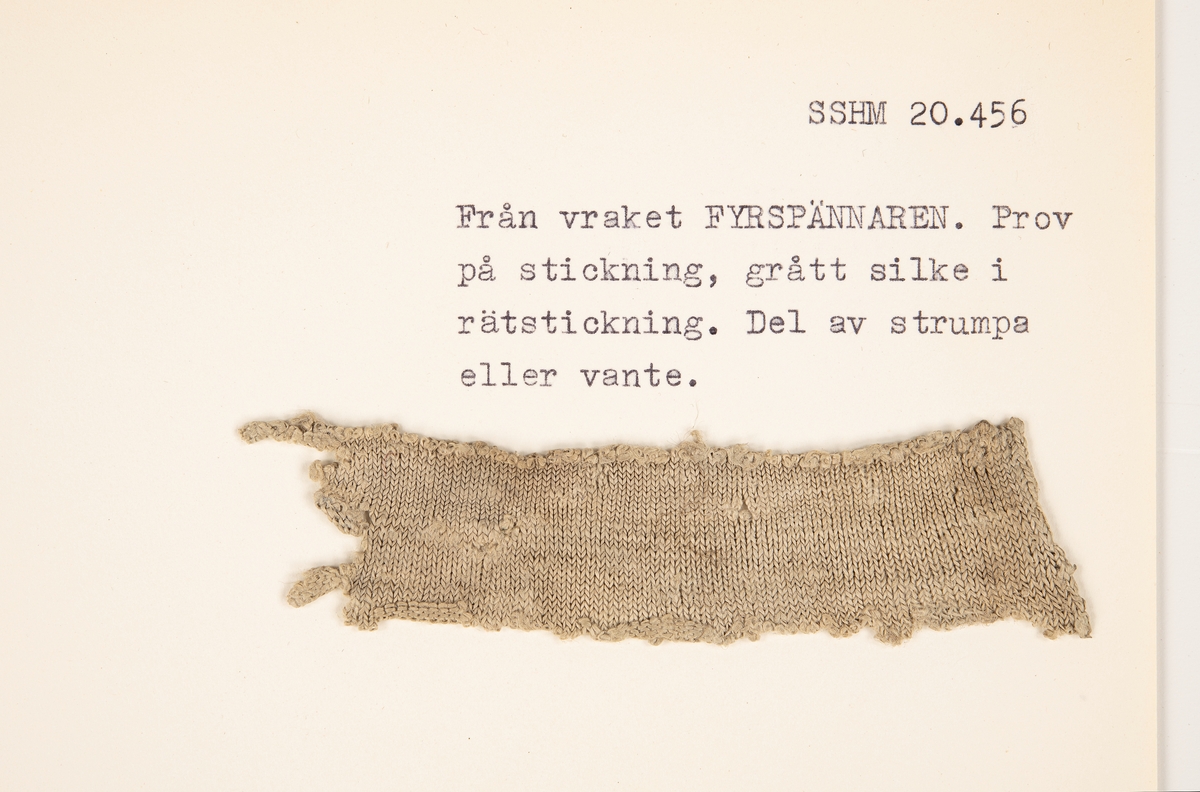 Fragment av grått silke, rätstickning.