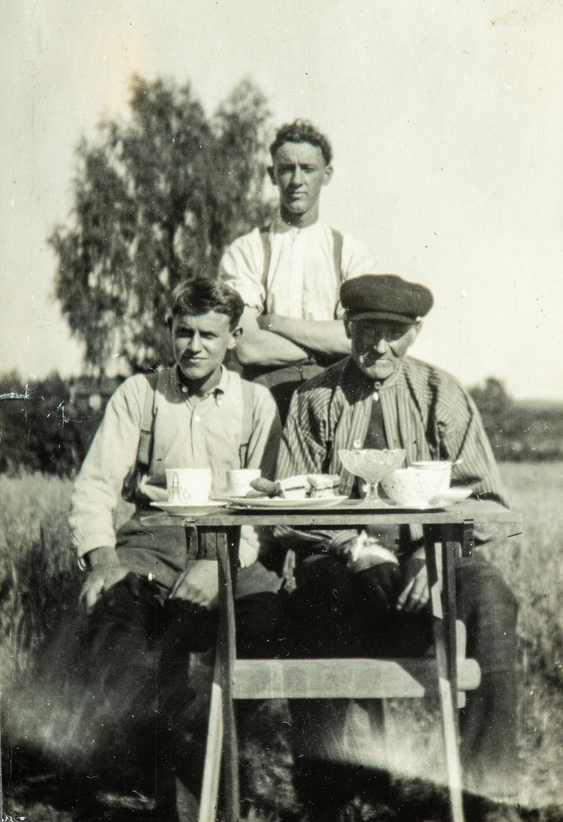 Gruppe 3 menn, kaffebord, Stående bak: Ole Petter Bakken, de 2 andre er ukjente.