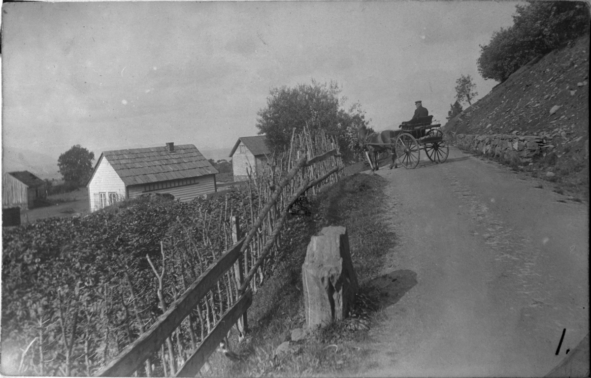 Svalland i Utbjoa, ca. 1915. Til venstre er det gamle skulehuset på Utbjoa. Huset vart flytta til Vikestølen og bygd om til hytte for bygdefolket. Personen i stolkjerra er ukjend.