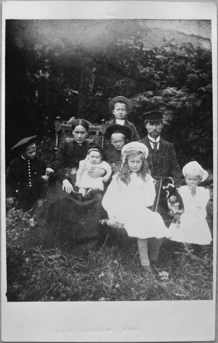 Familien Ekrheim i hagen utanfor A. Ekrheims hotell i Ølensjøen, ca. 1907. Frå venstre: Kasper Ekrheim, Anna Ekrheim (mor), Simon (eller Agnes?) Ekrheim (i fanget til Anna), Olaf Ekrheim, Toralf Ekrheim (bak Olaf), Anna ("Tulla") Ekrheim (foran Olaf), hotelleigar Aasmund Aasmundsson Ekrheim (far) og Katrine Ekrheim.