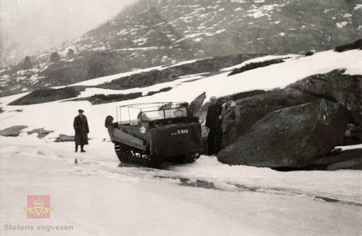 Beltevogn med kjenneteikn S-849 på Veitastrondi år1949. 

Beltebilen var innkjøpt av Sogn Billag for rutekøyring i Veitastrondi og på Sognefjellet.
Til venstre disponert Bjarne Drægni. Heilt til høgre står overingeniør Morten Helsing frå Vegkontoret.

Sjå også motiva NVM 14-F-01514, NVM 14-F-01515 og NVM 14-F-01520